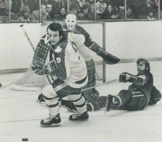Where did it go? Maple Leafs' Norm Ullman (9) can't seem to see puck as he wheels away from Vancouver Canuck's goal, guarded by rookie netminder Ed Dy(...)