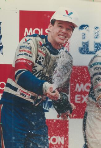 Victory splash: Al Unser Jr. pops the cork to celebrates his Molson Indy win yesterday. He defeated defending champion Michael Andretti in a dissappointingly slow race