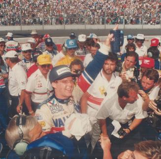 Al Unser Jr. raises a mug in celebration of his Molson Indy victory yesterday. He held the lead after the 16th lap, beating Danny Sullivan to the wire by 12.18 seconds