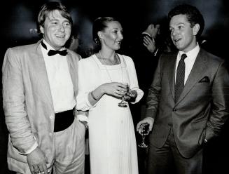 Looking suave and debonair in a linen tuxedo and cummerbund, Montreal designer John Warden, far left, chats with Pat McNulty and fellow designer Colin Watson