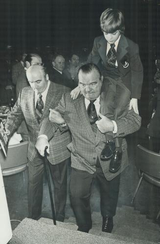 A traditiion is resumed: Escorted by Pat Flanagan, another former wrestler, Whipper Watson carries Timmy for 1973, 10-year-old Richard Ware, to head table at Sports Celebrities Dinner