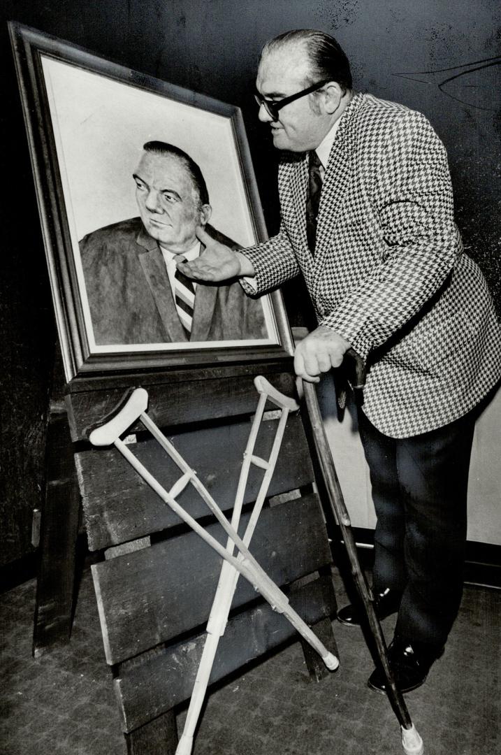 Whipper Billy Watson admires portrait presented to him in recognition of his work for Ontario Society of Crippled Children during press conference yes(...)