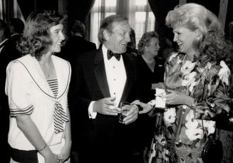 Enjoying a joke with comedian Frank Shuster, Wayne Shuster centre, are student Lisa Briers in a crisp cotton sailor dress, left, and real estate agent Carolyn Bolter, in an Italian silk print dress