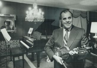 Leon Weinstein holds one of the treasured violins which he lent to the show to decorate his elegant but functional music room. In the background is a (...)