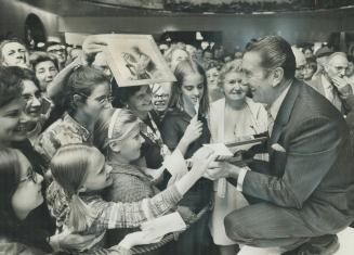 Bandleader Lawrence Welk autographs his book Wunnerful, Wunnerful at Sherway Gardens,