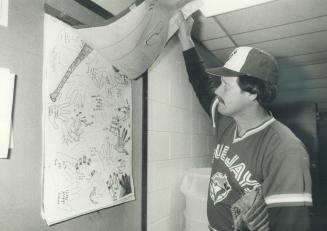 Ernie Whitt admires a poster that some young fans put together for the Jays