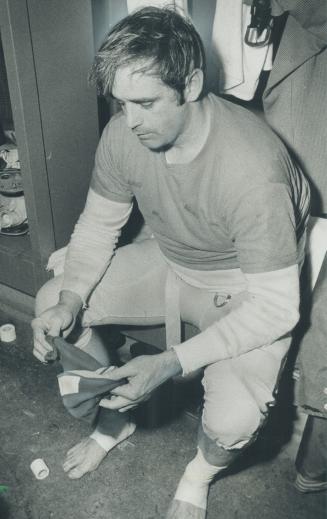 Agony of the Grey cup. Bitterness of defeat: Edmonton quarterback Tom Wilkinson sits alone in Eskimos' dressing room after his team was defeated, 22-18 Rough Riders for Grey Cup