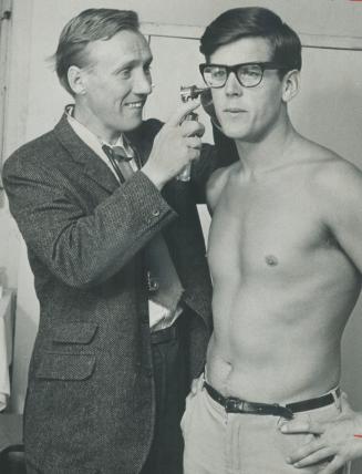 Fit for big swim. Seeking his third straight victory, Herman Willemse of Holland is examined by Dr. Hugh Smythe and declared fit for the CNE's 15 mile swim at the waterfront Friday