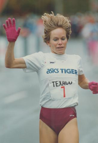 Wearing gloves to ward off Toronto's chill yesterday, Lynn Williams of Vancouver easily wins the women's mile at the annual Texaco Mile at queen's Par(...)