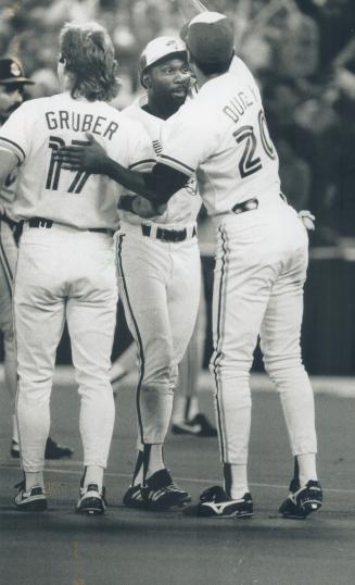 Hero's welcome: Mookie Wilson receives congratulations from Blue Jay teammates Kelly Gruber and Rob Ducey following his game-winning hit in the 10th inning yesterday