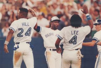 Mookie Wilson swaps high-fives with Glenallen Hill and Manny Lee after scoring the winning run in the ninth inning last night