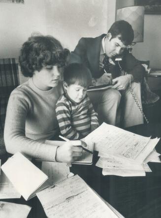 Home becomes an office: Viv Woolford keeps up with the phone calls while wife, Colleen, helped by son Graham, 4, does some of the paperwork involved in the mortages squeeze protest