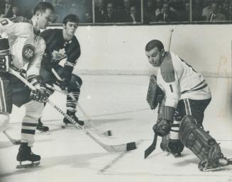 A kick in time. Canadiens' netminder, Gump Worsley, gets pad out in nick of time to deflect shot from stick of Maple Leafs' Jim Dorey (right) past corner of cage