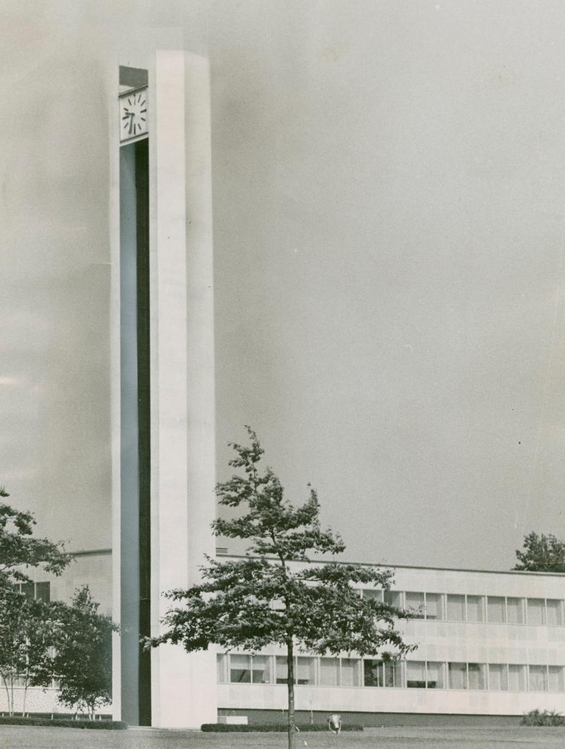 Tall, narrow, straight-sided concrete tower with numberless clock face at top.