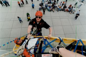 Easy now: St. John Ambulance volunteer Ian Furst demonstrates rappelling and lowers Councillor Kyle Rae in a basket 10 metres (35 feet) down a wall at(...)