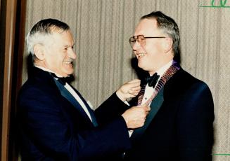 MDs get new chief: Dr. Earl Myers (left), outgoing president of the 17,000-member Ontario Medical Association, places the chain of office on Dr. Richard Railton, a 54-year-old Welland surgeon