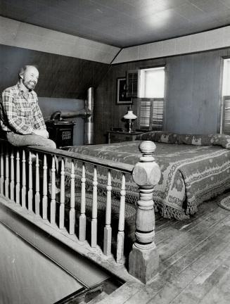 Master bedroom: Original railing, wood floor and stove, above, give the bedroom of couple's 140-year-old farmhouse in Alliston a warm, cosy atmosphere