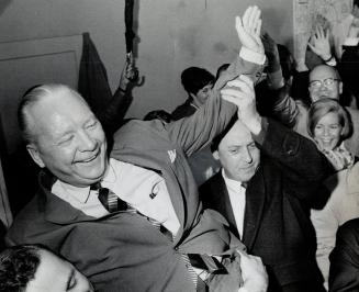 Ted high on the shoulders of his supporters, Economics Minister Stanley Randall gives a victory wave last night after holding his of Don Mills, though(...)