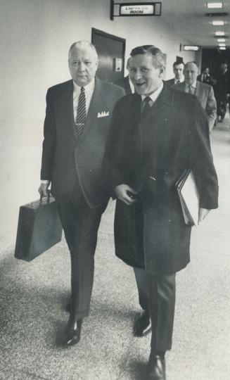 Can they solve the housing crisis? Carrying briefcase, federal Transport Minister Paul Hellyer and executive assistant Lloyd Axworthy (left) enter fed(...)