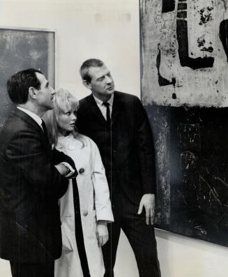 A town in Yucatan is picture's title and artist Jack Reppen, right, hears comments from Walter Carsen, left, and noted collector Kirsikka Schmalfuss. (...)