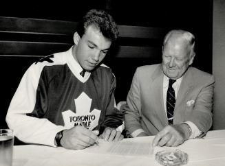 Big day for Luke, H.B.: Last year the Leafs' first-round draft pick was defenceman Luke Richardson, here signing on the dotted line under the gaze of club owner Harold Ballard