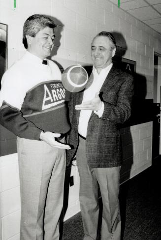 It's in your hands now. Toronto Argonauts owner Harry Ornest tosses the football to Adam Rita yesterday after he was named the team's new head coach. (...)