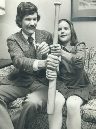 Movie director Michael Ritchie shows his daughter, Lauren, 9, how a baseball bat is used to decide who bats first, one of the things he taught young a(...)