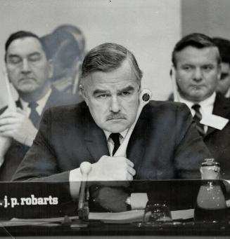 At centre is Ontario's Premier John Robarts, who appears grim-faced at Johnson's remark