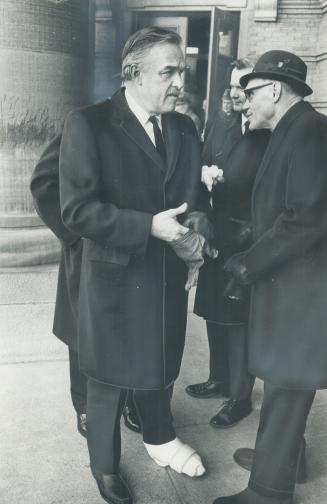 At funeral of Senator Wallace McCutcheon yesterday, Premier John Robarts, his foot in cast after a recent fall, talks to Chancellor Dr. O. M. Solandt (right)