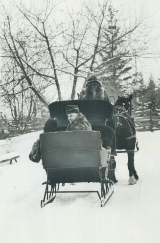 Premier John Robarts, in coonskin coat, rides in a horse-drawn cutter yesterday at Black Creek Pioneer Village during filming of his final Christmas m(...)