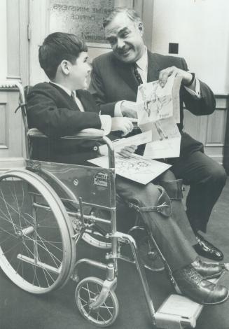 Timmy' visits Robarts. Ian Walmsley of Oshawa, who as Timmy symbolizes the Easter seal fund campaign, shows Premier John Robarts campaign posters during visit to Queen's Park