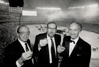 Mission accomplished: Dome architect Rod Robbie, centre, toasts the opening with partners Michael Allen, left, and Bill Neish at last night's gala at the $500 million stadium