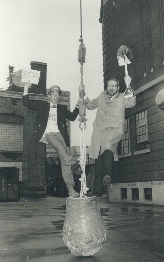 Balls o' fun: Stadium Corp. president Chuck Magwood (left), with the building permit, and architect Rod Robbie celebrate on a wrecking ball poised to flatten buildings on the dome site