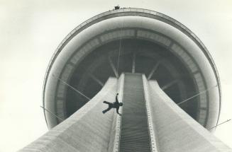 The big plunge. Hanging by a thread of cable, stuntman Dar Robinson launches himself from the 1,100-foot level of the CN Tower last Tuesday, a day aft(...)