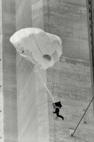 The long fall: Stuntman Dar Robinson leaps well out from CN Tower to avoid obstacles on way down, then free falls before pulling parachute ripcord