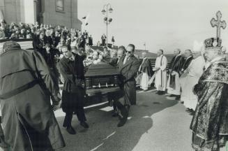 Final Tribute: Church dignitaries watch solemnly as pallbearers pass yesterday with the coffin of popular Markham mayor