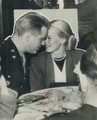 Col. Elliott Roosevelt, second son of President Roosevelt, and Faye Emerson, blonde actress of the films, put their heads together at a Hollywood nigh(...)