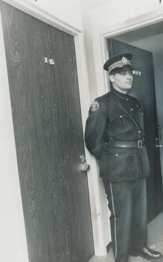Apt. 615 at Sutton Place, in which bomb exploded in stock promoter Myer Rush's bed, is guarded by policeman. Early morning blast blew the figure 6 off the door