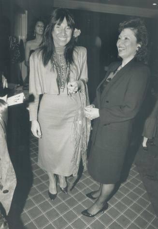Buffy Sainte-Marie, wearing a short red silk dress, arrives for the party at Stop 33 with Delia Opekokew