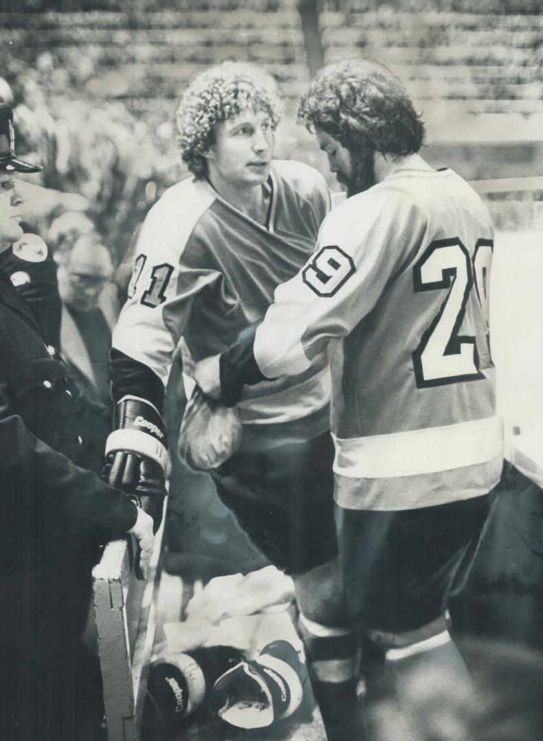 In penalty box, Don Saleski (left) and Jack McIlhargey of Philadelphia Flyers appear to be comforting each other during brawl-filled game against Mapl(...)