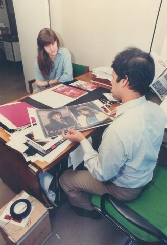 Above, Avon cosmetics art director Henry Isdith goes through Monika Schnarre's portfolio with her