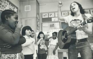 Bob Schneider, right, strums guitar and helps children create their own songs in North York school