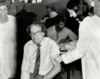 Getting the needle. Toronto Mayor John Sewell rolled up his sleeve, gritted his teeth and took his medicine yesterday from Dr. Gillian Peterson (right(...)