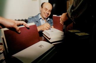 Freed Soviet dissident Natan Sharansky, left, autographs a copy of his book, Fear No Evil, at Edwards Books and Art in Metro. In February, 1986, photo(...)