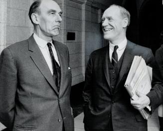 A sharp sally apparently fails to hit the funny bone of Opposition Leader Robert Stanfield as he and Finance Minister Mitchell Sharp wait for a slow e(...)