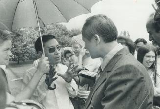 Huynh Van Ba (under umbrella), a South Vietnamese representative of the Viet Cong, went to the U.S. border at Fort Erie yesterday to talk to Rochester broadcaster Warren Doremus, whose brother is a prinsoner in North Viet Nam. Ba has been in Toronto since Monday for meetings with anti-draft and other groups.
