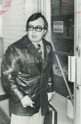 Bank Manager Kenneth Bates locks up his North York office after thwarting a robberty when he recognized a man he believed was same suspect who held up his branch in September, 1975. Police shot the suspect in the leg.