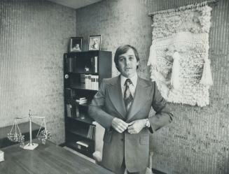 Lawyer John Bell, who is with the firm of Shibley, Righton, McCutcheon inherited most of his office furniture when he took over his office. He decided he liked the existing green color scheme but added personal touches like the multi-textured wool hanging, family photographs.