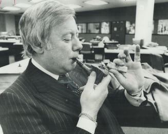 The ultimate in smoking luxury - Peter Bone, executive director of Rothman's demonstrates how it might be for the sybaritic smoker with money to burn. The hand-crafted, solid gold lighter and one of-a-kind briar pipe went on sale today at the Eaton Centre. Bone, a cigarette smoker, said cost is $16.700.