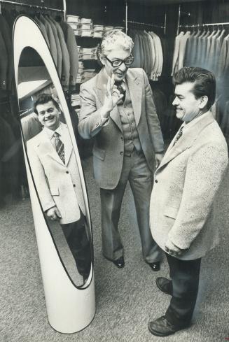 An event five feet tall, Harry (Bob) Voulgaris, a restaurant owner (right), is fitted for a sports jacket in a new clothing shop restricted to men no taller than five-feet-five inches. Shop owner Lou Brown, left, says short men, generally pay too much for clothes, suffer humiliation in some stores.